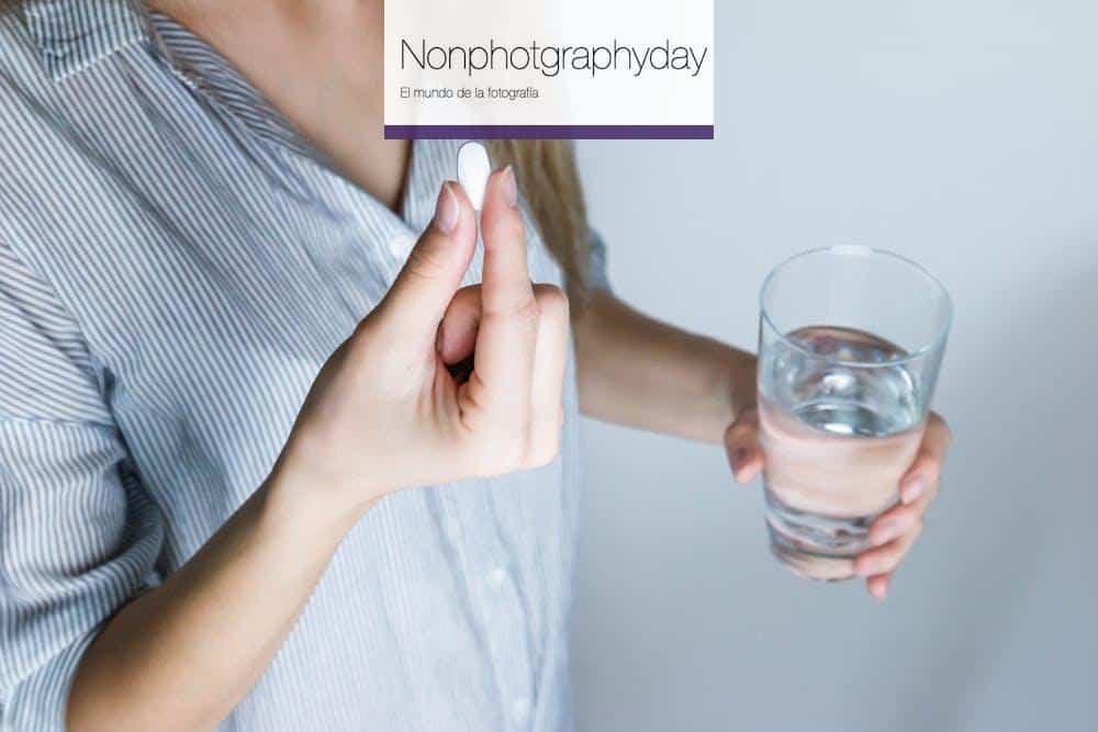 Woman Holding Half-full Glass and White Medicine Pill