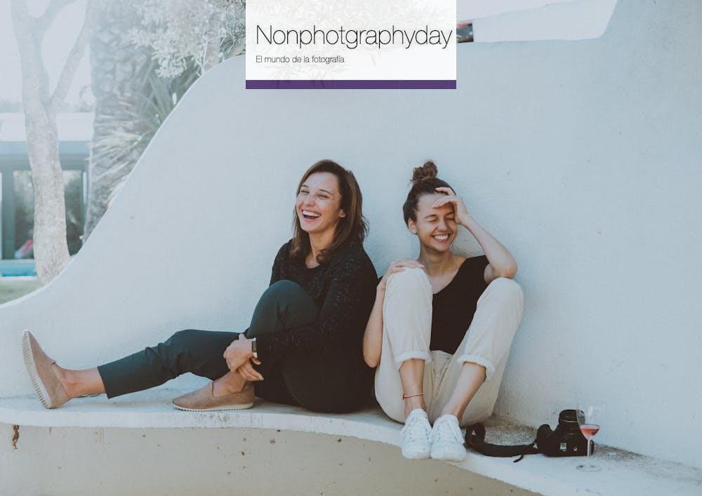 Two Women Sitting on White Bench