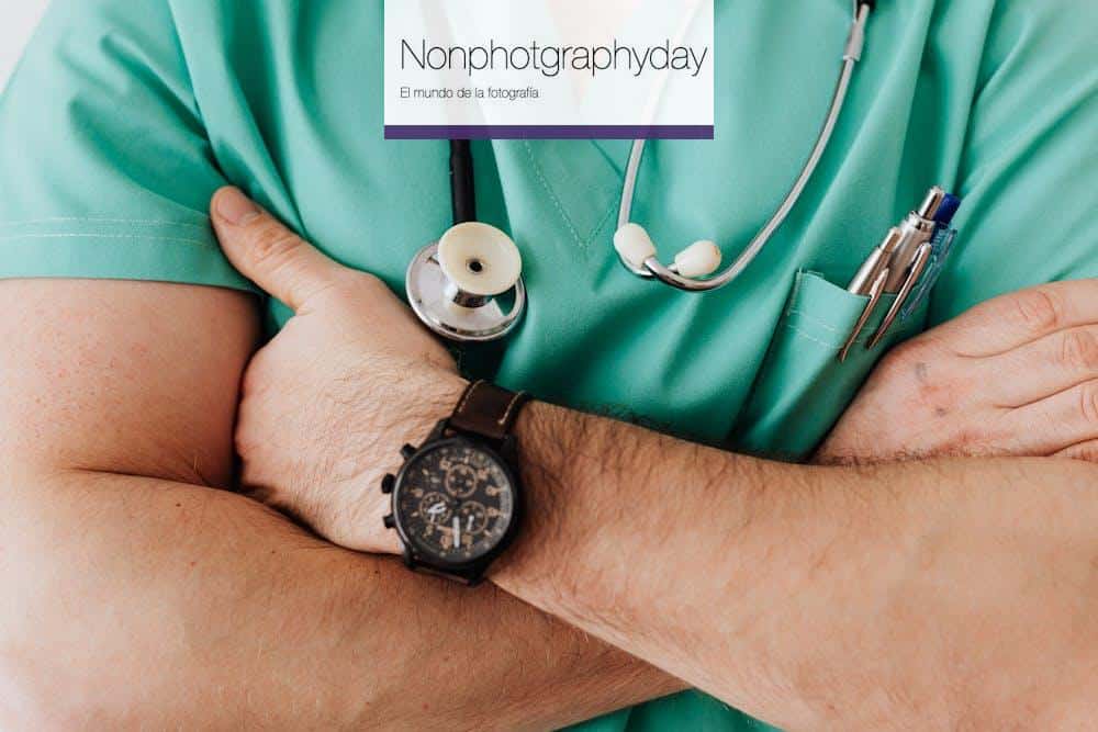 Close-up of a healthcare professional with arms crossed wearing medical scrubs and stethoscope.