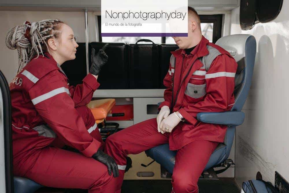 Two paramedics in uniform discussing inside an ambulance, focused on emergency healthcare.